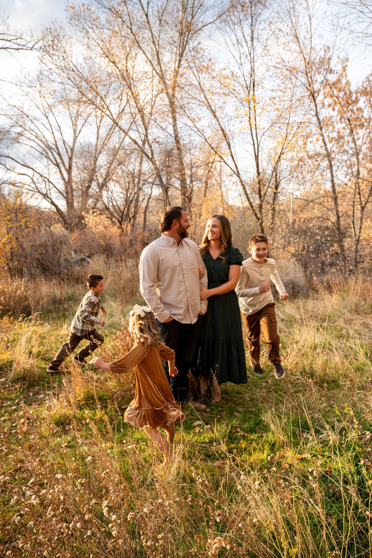 Family of five walking together through an autumn field
